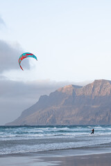 Kite surfer navigates the waves at Famara beach, showcasing thrilling skills