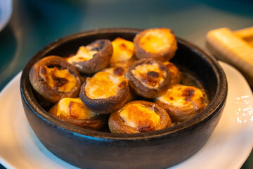 Delicious mushrooms stuffed with cheese baking in a clay pot, turning golden brown and crispy, creating a mouthwatering appetizer. Aroma fills the kitchen, promising a tasty meal