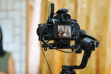 A professional camcorder with a blurred image on the screen. Shooting holidays and interviews.