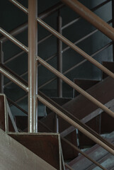 Vertical view of Old metal steps with handrails against concrete wall background. Side view of Steel ladder, Space for text, Selective Focus.