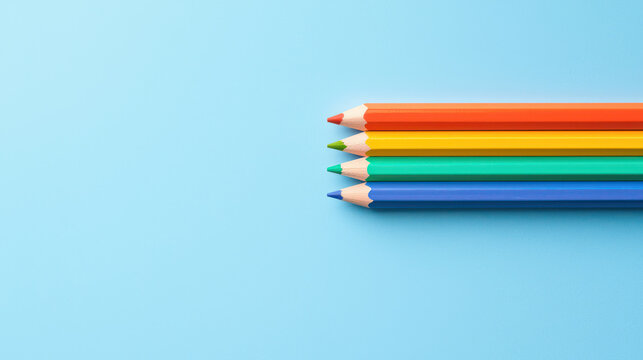Colorful pencils arranged on blue background create vibrant and minimalistic composition