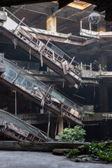 Fototapeta premium Dramatic view of Damaged escalators inside Abandoned new world shopping mall building. Structural and ruins was left to deteriorate over time. use it as your wallpaper, Poster and Space for text, Sele