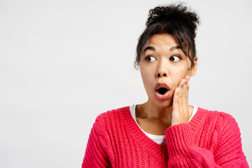 Shocked young woman gasping and touching her face in amazement