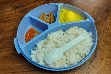 Rice side dishes in a blue Tupperware lunch box on the table