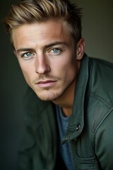 Fototapeta premium Close-up portrait, young man, blond hair, green jacket.