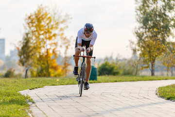 Cyclist riding on a pathway surrounded by autumn foliage in a park