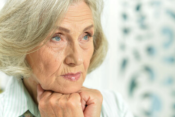 Portrait of a sad elderly woman posing at home