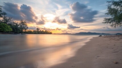 Obraz premium Serene beach sunset with long exposure capturing dynamic clouds and water movement over soft sandy shore and distant mountains.