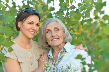 An elderly woman with her daughter in the park in summer