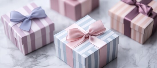 Colorful striped and plain gift boxes with ribbons on a marble surface ideal for holiday or celebration themed marketing and advertising purposes