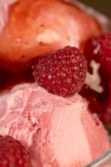 red raspberry ice cream in a glass bowl with raspberry jam