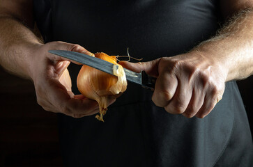 A person is carefully removing the skin from a fresh onion using a sharp knife. The warm, subtle lighting creates a cozy atmosphere, emphasizing the art of cooking in the kitchen