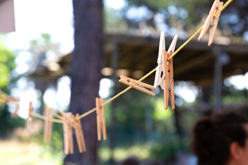 A collection of clothes pins is hanging on a clothes line outdoors