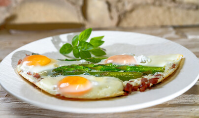 Homemade food, breakfast, fried eggs with asparagus and spices. Light background.