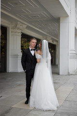Fototapeta premium An Elegant Bride and Groom Together, Posing in a Beautiful Urban Setting Filled with Joy