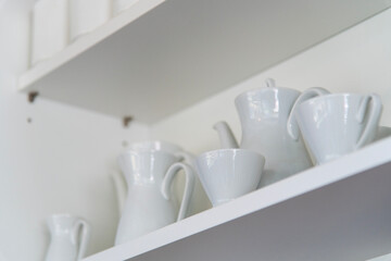 ceramic tea cup and kettle on the shelf