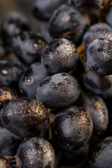 fresh grapes are lying on black paper