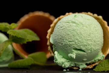 green ice cream with mint flavor on a black slate surface