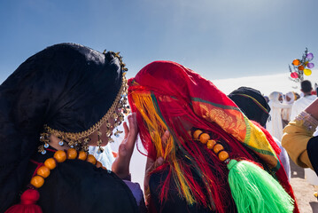 Merzouga, Morocco, 12, 6, 2023. A woman talks to te bride in the ear dressed in traditional gala...