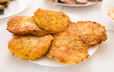 Potato pancakes with sour cream on white plate