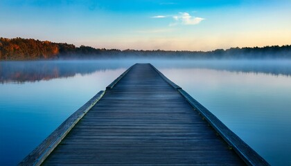 Fototapeta premium a serene pier stretching into a misty blue lake at dawn