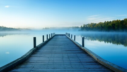 Obraz premium a serene pier stretching into a misty blue lake at dawn travel destinations
