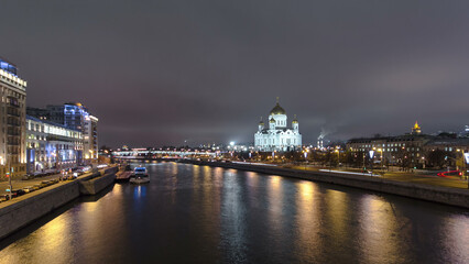 Majestic orthodox Cathedral of Christ Saviour illuminated at dusk on bank of Moscow river. Timelapse hyperlapse, Russia