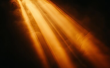 A hazy picture with a radiant sun, featuring sunbeams, sunrays, and a warm yellow-orange light effect, all set against a black background with golden beams and stardust.