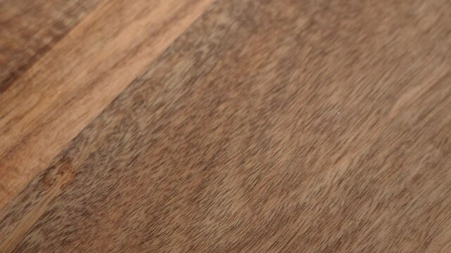 Hand taking a set of keys with wooden house shaped keyring on textured surface close up. Property ownership and renting concept