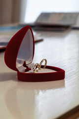 gold wedding rings in a red heart-shaped box
