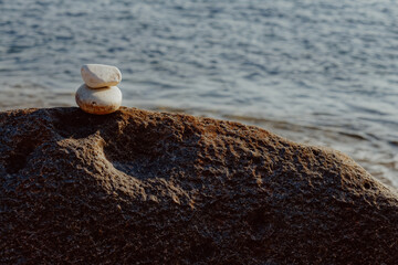 Oval stones arranged on a rock on the background of the sea, relaxation on the beach, future planning, feng shui, relaxation on vacation
