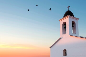 Solitary church bell tower against a pastel sky at sunset with birds in flight, symbolizing peace and spirituality.