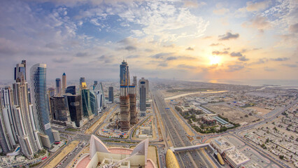 Dubai business bay towers with sunset timelapse. Rooftop view of some skyscrapers and new towers...
