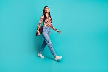 Full length photo of cheerful pretty lady dressed retro shirt walking holding modern gadget empty space isolated blue color background