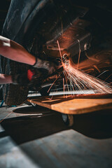 Mechanic flexes on car with flying sparks