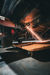 Mechanic flexes on car with flying sparks