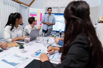 Fototapeta premium Project manager communicate and collaborate with team using project management software display on monitor, tracking progress of project task and making schedule plan at meeting table. Prudent