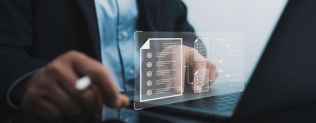 Businessman navigating a laptop with digital document management overlays. Organized files and...