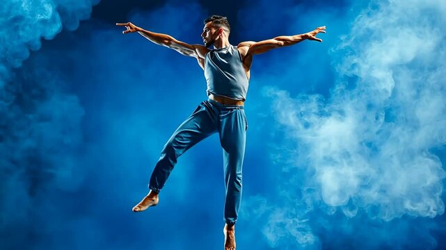 Energetic male dancer leaping against dramatic smoky blue backdrop capturing motion