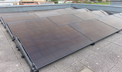 Compact solar panel system installation on modern rooftop terrace © VeugerStock