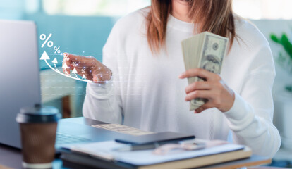 businessman holding, banknotes with high percentage on,laptop screen, finance and investment concept,digital marketing strategy, financial growth, wealth creation,online business and,economic success.