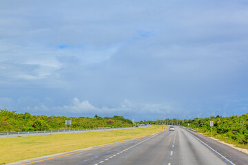 A long, empty highway with a few trees in the background