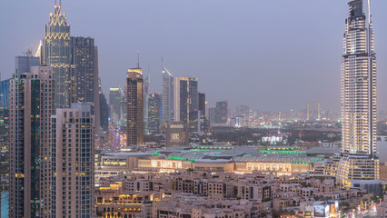 Fototapeta premium Dubai Downtown day to night timelapse. Aerial view over big futuristic city by night.
