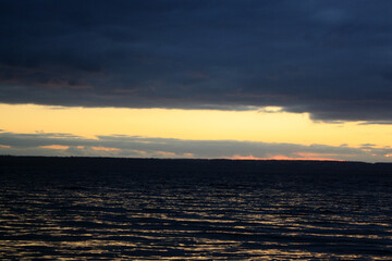 a sunset over a lake with a sunset in the background.