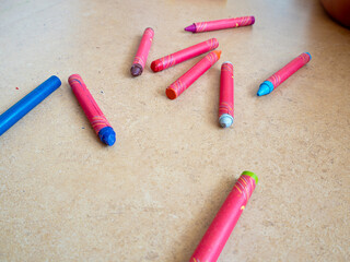 Crayons strewn on the floor While the children are playing and coloring
