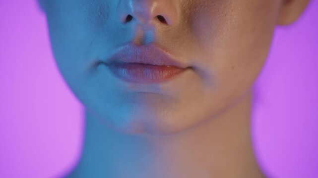 Close-Up Of Woman's Mouth Licking Lips With Tongue, Colorful Studio Shot
