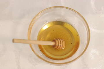 Honey bee in a bowl of honey.A bowl with honey and a dipper to take honey
