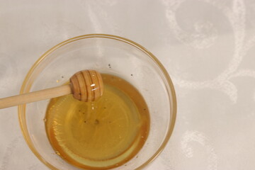 Honey bee in a bowl of honey.A bowl with honey and a dipper to take honey
