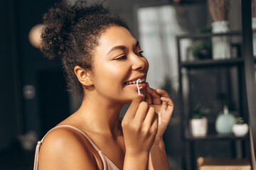 Young woman cleaning teeth with dental floss in bathroom