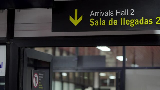 Arrivals sign at an airport, sign in English and Spanish